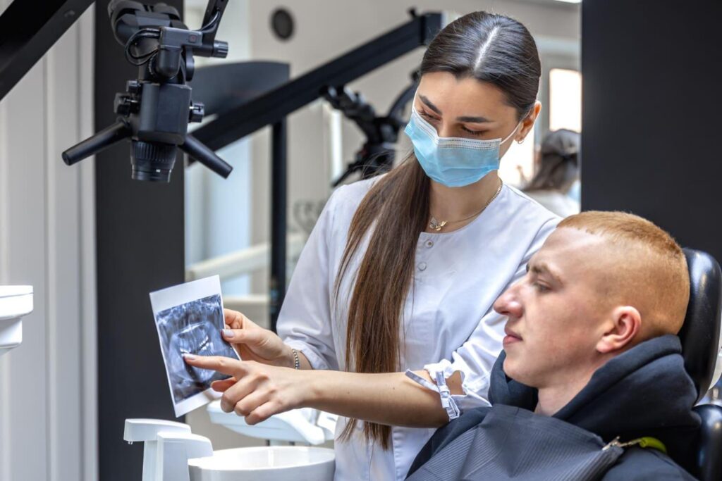 Dentist showing a patient their dental X-ray while planning implant treatment